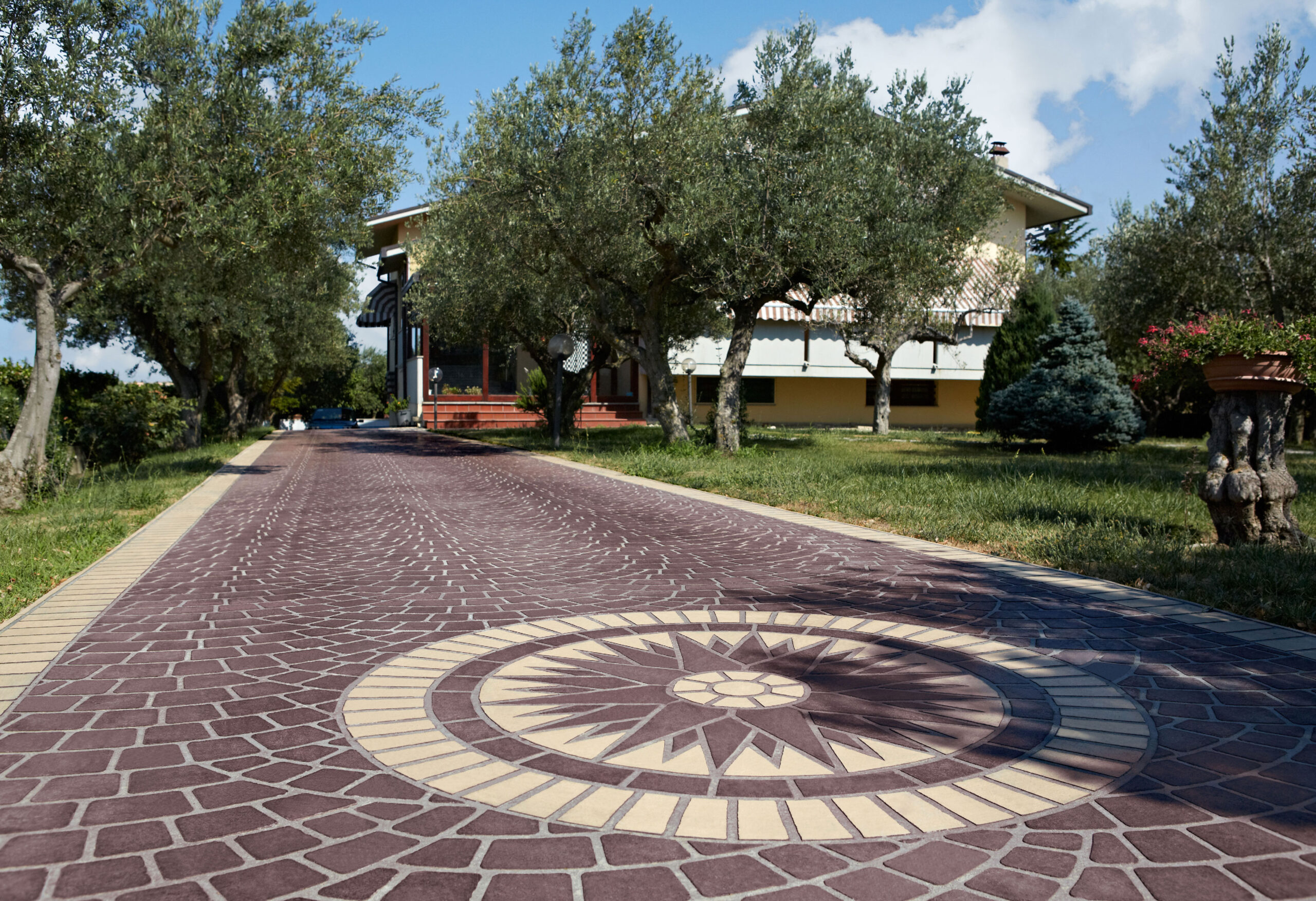 Il pavimento Stenciltop impreziosisce un viale tra gli ulivi riproducendo l'effetto di cubetti in profido